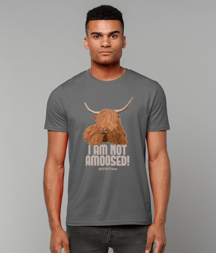 Male model wearing 'I AM NOT AMOOSED' Print on Dark Grey Sustainable T-Shirt. Unisex/Women/Men. Certified Organic Clothing. Original Highland Cow Illustration by Artfully/Wild.