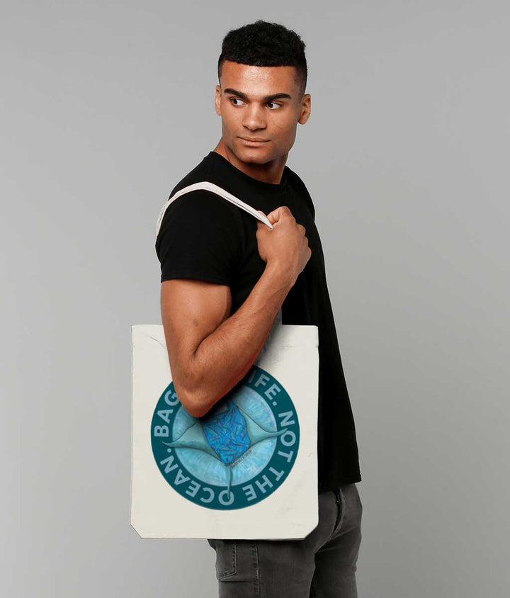 Man modelling 'BAG FOR LIFE. NOT THE OCEAN' Recycled Canvas Tote Bag Natural. Original Design by Artfully Wild.
